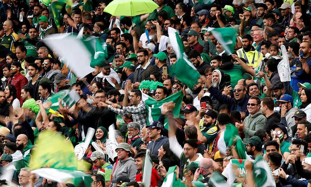 Cricket fans cheering with flags and banners for the ICC Champions Trophy 2025