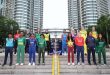 Group photo of ICC Women’s U19 T20 World Cup 2025 team captains in front of the Petronas Towers, standing around the tournament trophy in vibrant jerseys.