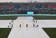 Ground staff covering the cricket field with protective sheets due to rain at Rawalpindi Stadium during the ICC Champions Trophy 2025.